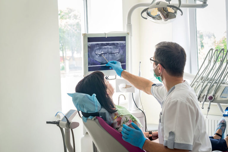 A dentist showing a patient x-ray