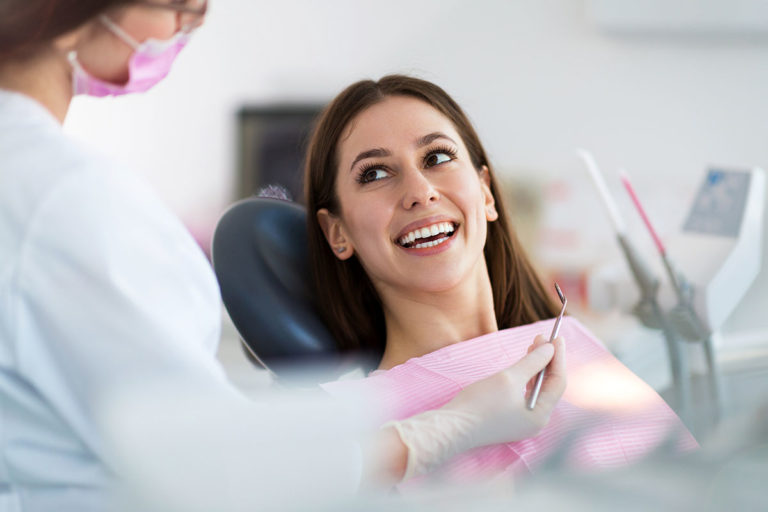 A woman smiles during her dental exam