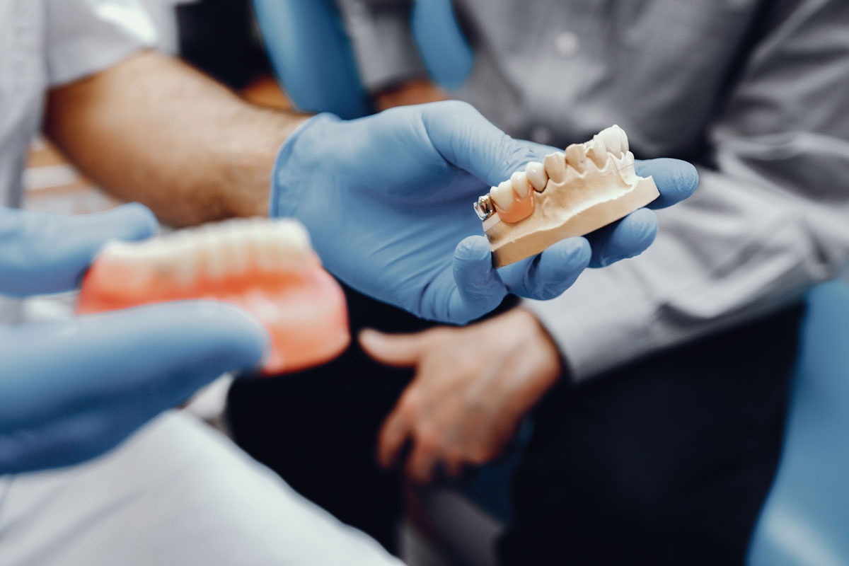 dentist shows dental bridge to patient