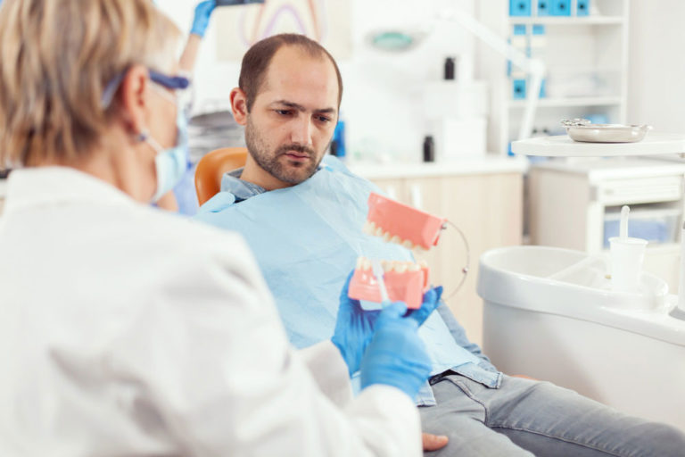stomatologist explaining dental implants to the patient